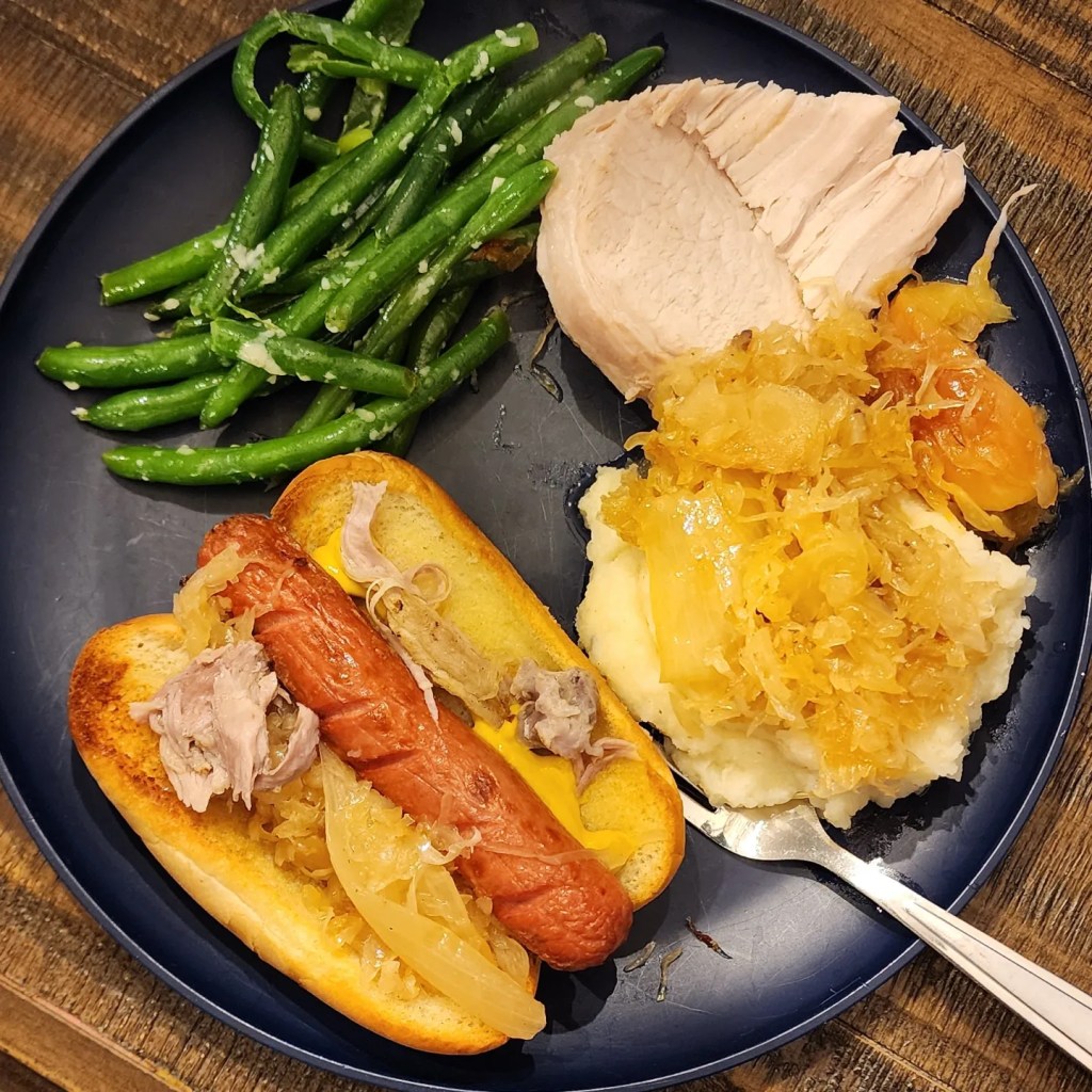 Paremesan/Butter steamed green beans, pork, mashed potatoes & sauerkraut, & a hot dog on a home made-ish roll with sauerkraut, shredded pork, & yellow mustard.