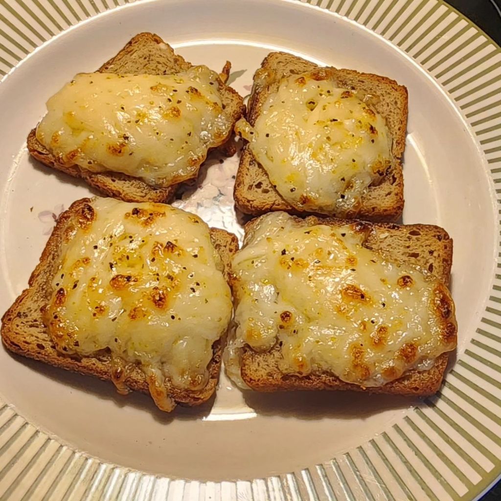Four lemon pepper cocktail rye bread appetizers arranged on a plate.