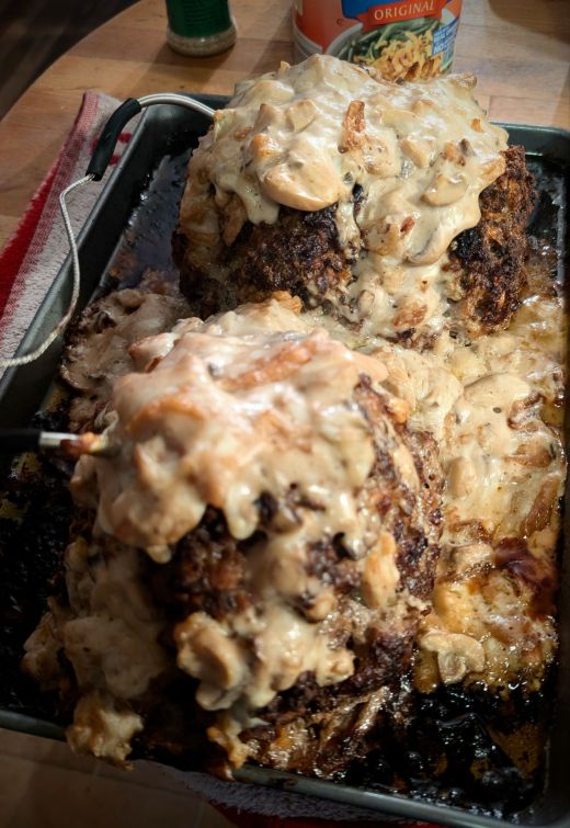 Two freshly baked meatloaves topped with cream of mushroom soup and crispy fried onions, resting on a sheet pan.