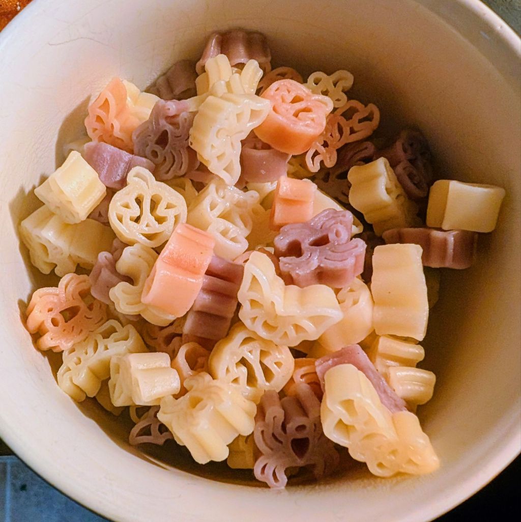 Reggano Halloween Shaped Pasta in a bowl.  Pumpkins, bats, owns, spiders, & more in "regular" color, orange, and purple.
